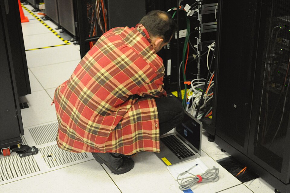 A data-center technician working on a server rack at NERSC